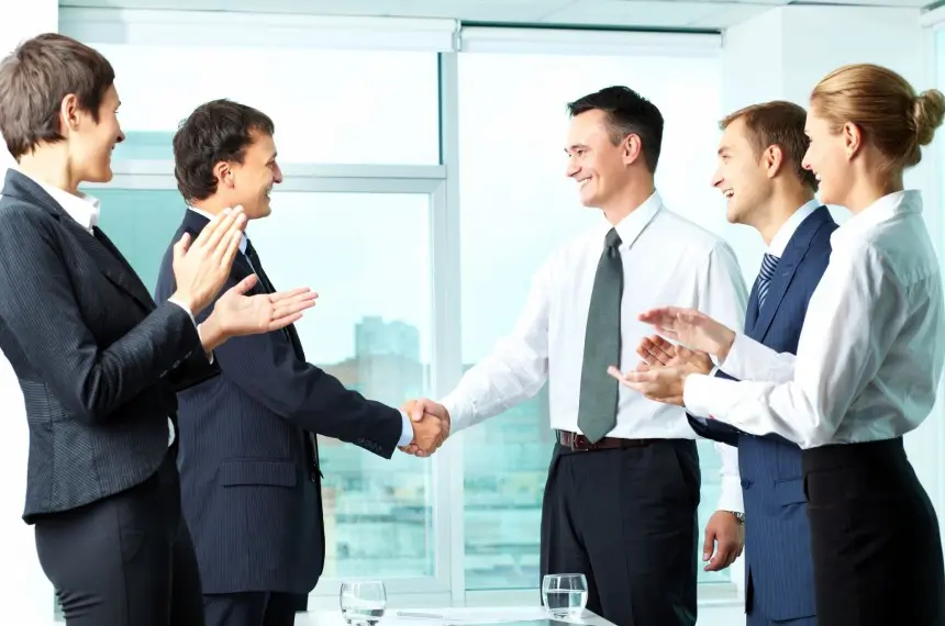 A group of people in suits shaking hands.